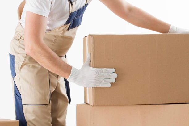 Relocation services concept. Mover in uniform with cardboardboxes isolated on white background Relocation services concept. Mover in uniform with cardboardboxes isolated on white background. moving company stock pictures, royalty-free photos & images