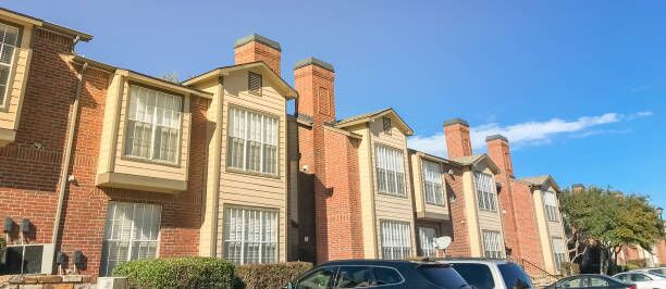 Panoramic view exterior of apartment building in suburbs Dallas, Texas Panorama view typical apartment complex near Dallas, Texas, USA with uncovered parking lots and high retaining wall apartment movers Dallas stock pictures, royalty-free photos & images