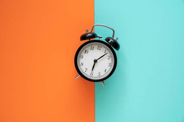 Retro alarm clock on color table background, vintage style Retro alarm clock on color table background, vintage style time saving stock pictures, royalty-free photos & images