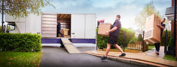 Removal team loading removal truck Removal company helping a family move out of their old home moving company stock pictures, royalty-free photos & images