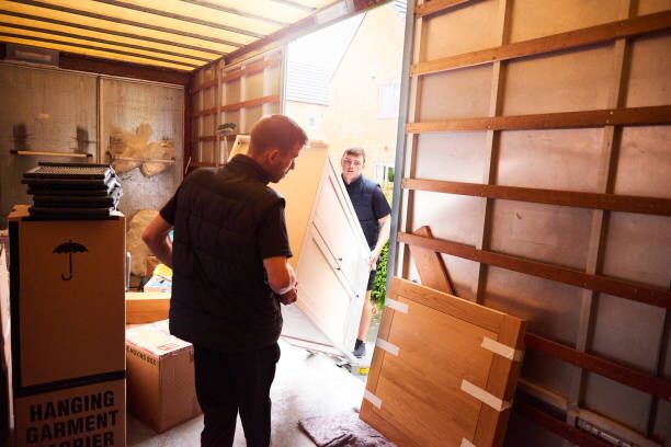 Loading furniture into removal truck Removal company helping a family move out of their old home residential movers stock pictures, royalty-free photos & images