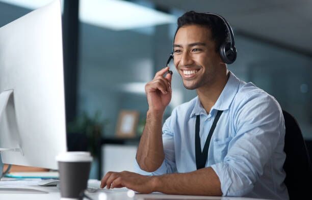 Shot of a young man using a headset and computer in a modern office Have you heard about our latest package? call customer service stock pictures, royalty-free photos & images