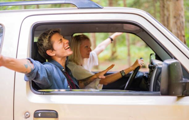 Singing and enjoying the journey. Photo of a young couple riding in a car on a bright summer day during their road trip karaoke in car stock pictures, royalty-free photos & images