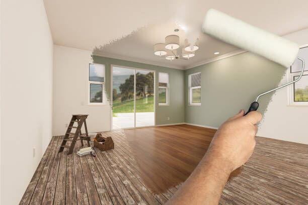 Before and After of Man Painting Roller to Reveal Newly Remodeled Room with Fresh Light Green Paint and New Floors. Before and After of Man Painting Roller to Reveal Newly Remodeled Room with Fresh Light Green Paint and New Floors. apartment interior stock pictures, royalty-free photos & images