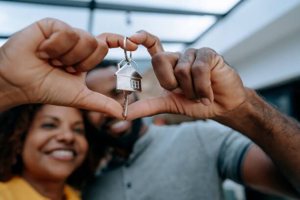 Couple second key to new home with hand in heart symbol Couple second key to new home with hand in heart symbol moving in stock pictures, royalty-free photos & images