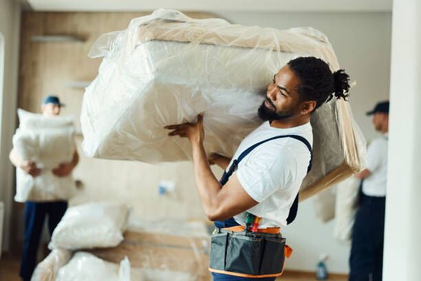 Young black mover carrying furniture in a new apartment. African American male mover carrying furniture in the apartment. moving in stock pictures, royalty-free photos & images