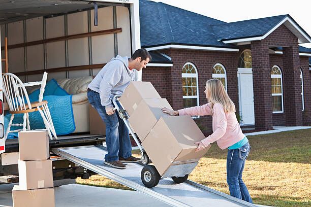 Couple unloading boxes from moving van Mid adult couple (30s) unloading moving van. moving truck stock pictures, royalty-free photos & images