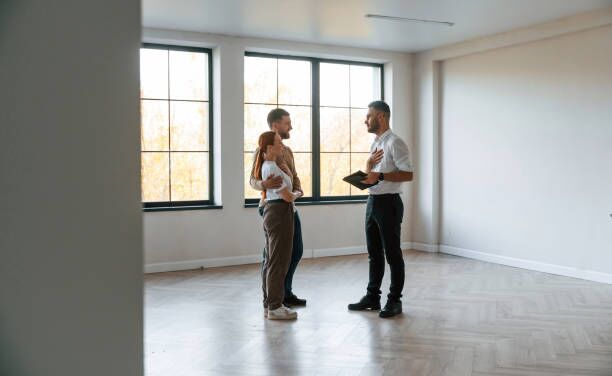 Empty room. real estate agent shows an apartment to a young couple Empty room. real estate agent shows an apartment to a young couple. apartment stock pictures, royalty-free photos & images