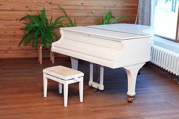 Stylish White Piano White piano and chair in empty room near window piano movers stock pictures, royalty-free photos & images
