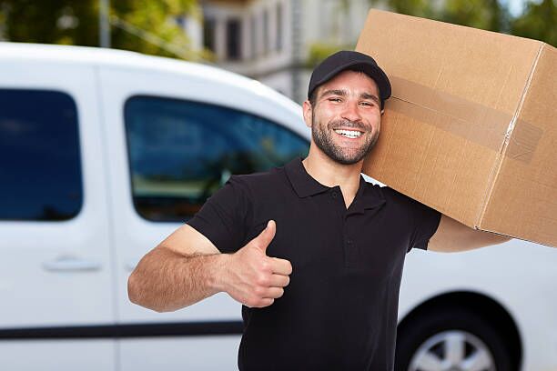 Smiling delivery man Smiling delivery man holding a paper box moving company stock pictures, royalty-free photos & images