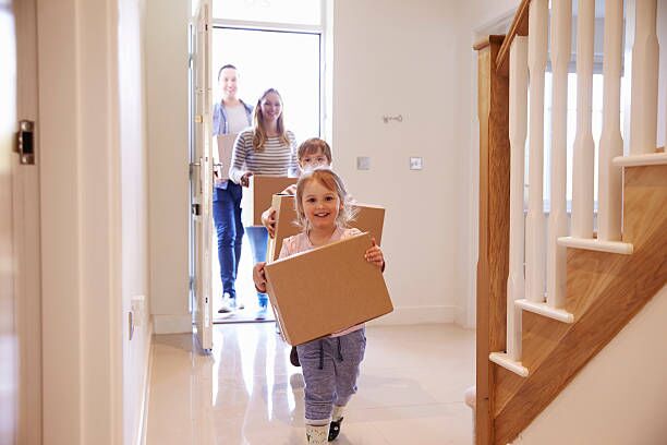 Family Carrying Boxes Into New Home On Moving Day Family Carrying Boxes Into New Home On Moving Day moving family stock pictures, royalty-free photos & images