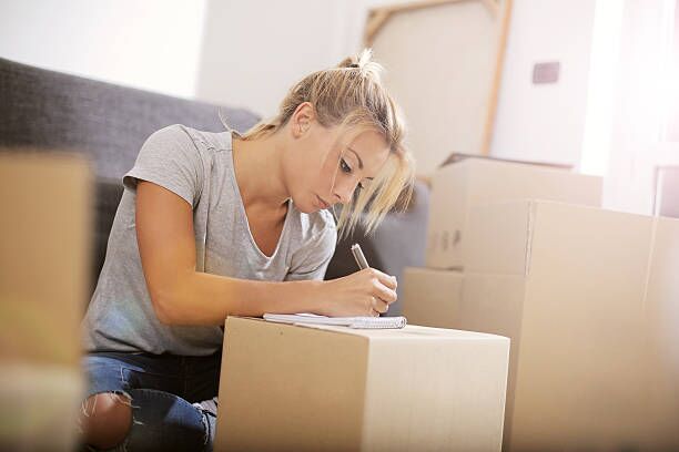 Make a to do list A young beautiful women makes her notes and plans in her new flat summer moving homes stock pictures, royalty-free photos & images