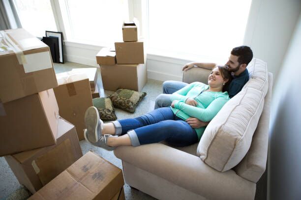 Moving Day A couple relaxing on a sofa after moving in/out long distance movers stock pictures, royalty-free photos & images